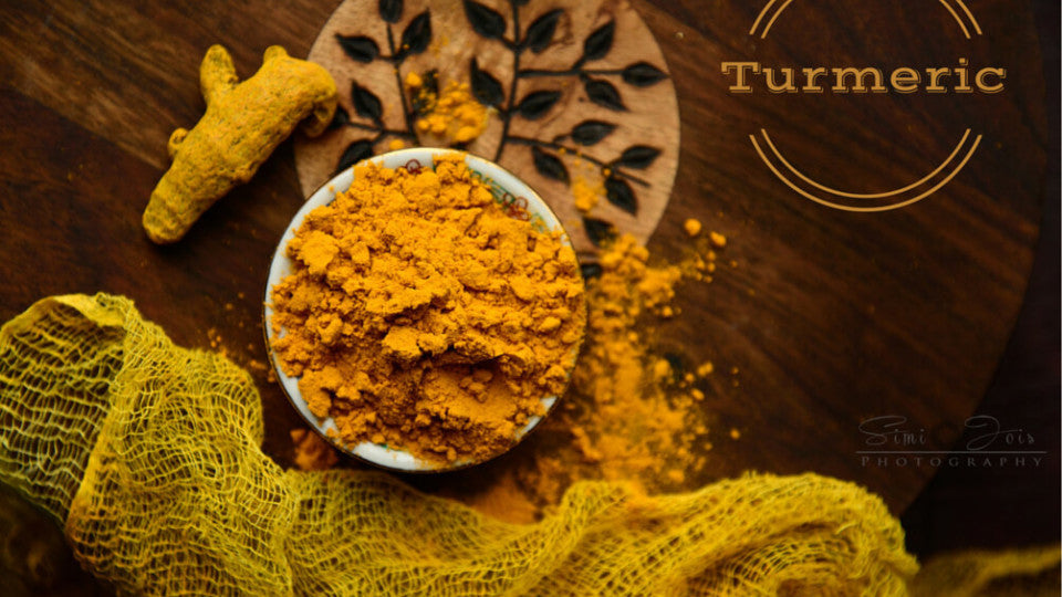 Turmeric powder and turmeric root on table