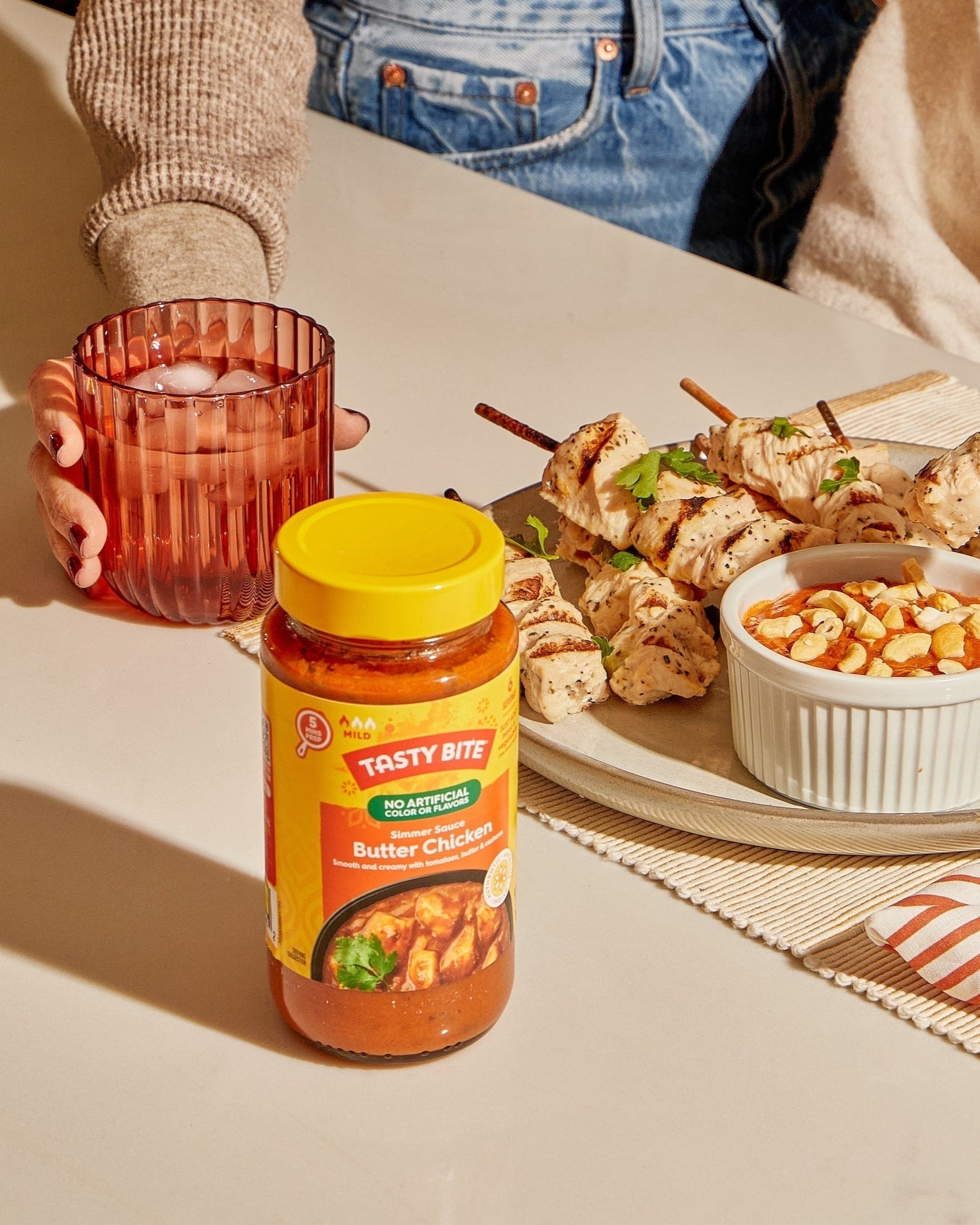 Tasty Bite Butter Chicken Simmer Sauce jar with chicken skewers and cashew curry