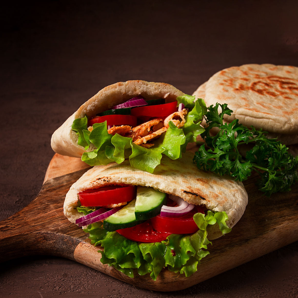Fresh pita sandwich stuffed with lettuce, cucumber, tomato, and onion